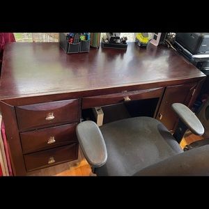 Office desk with rolling chair. Chair has stain from cleaner, not done properly.
